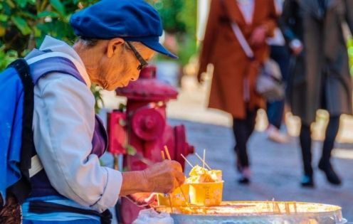 An elderly Naxi woman selling Naxi rice cakes in Lijiang Ancient Town
