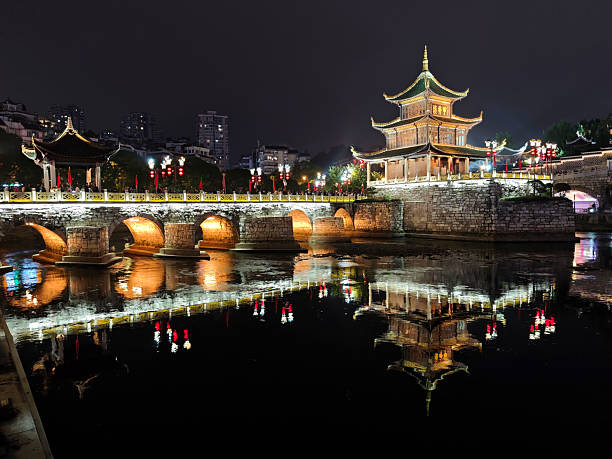 The Jiaxiu Pavilion at night, located in the southern tip of the Nanming River, which is Guiyang's emblem and its symbol. It was initially built in 1598 during the Ming Dynasty and was destroyed multiple times in history. It was being rebuilt most recently in 1982. Guizhou province, China.